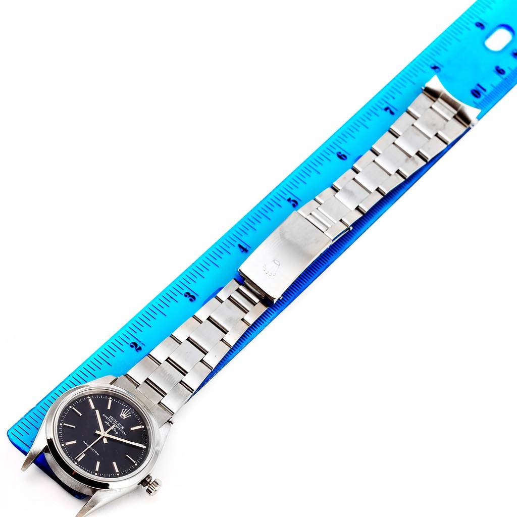 The Rolex Air-King 14000 Men's Stainless Steel Black Dial 14000 Men's Stainless Steel Black Dial watch is shown laid flat with a blue ruler, highlighting the face, bracelet, and clasp parts.