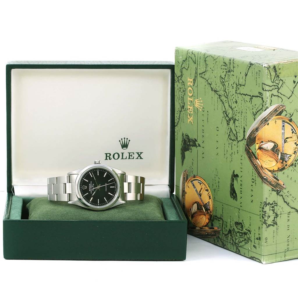 The Rolex Air-King 14000 Men's Stainless Steel Black Dial 14000 Men's Stainless Steel Black Dial watch is shown front-facing inside an open green box, with its branded case displayed beside it.