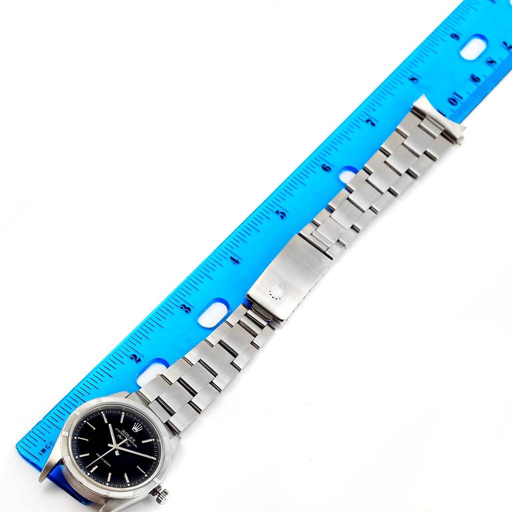 The image shows a Rolex Air-King 14010 Men's Stainless Steel Black Dial 14010 Men's Stainless Steel Black Dial watch laid flat beside a ruler, displaying its face, bezel, bracelet, and clasp from a top-down angle.