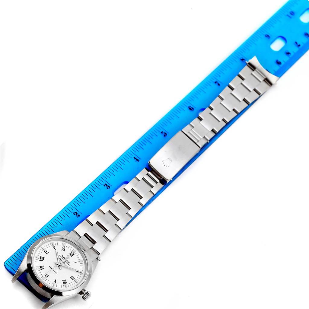 The Rolex Air-King 14000 Men's Stainless Steel White Dial 14000 Men's Stainless Steel White Dial watch is shown lying flat next to a blue ruler, displaying the watch face and metal bracelet.