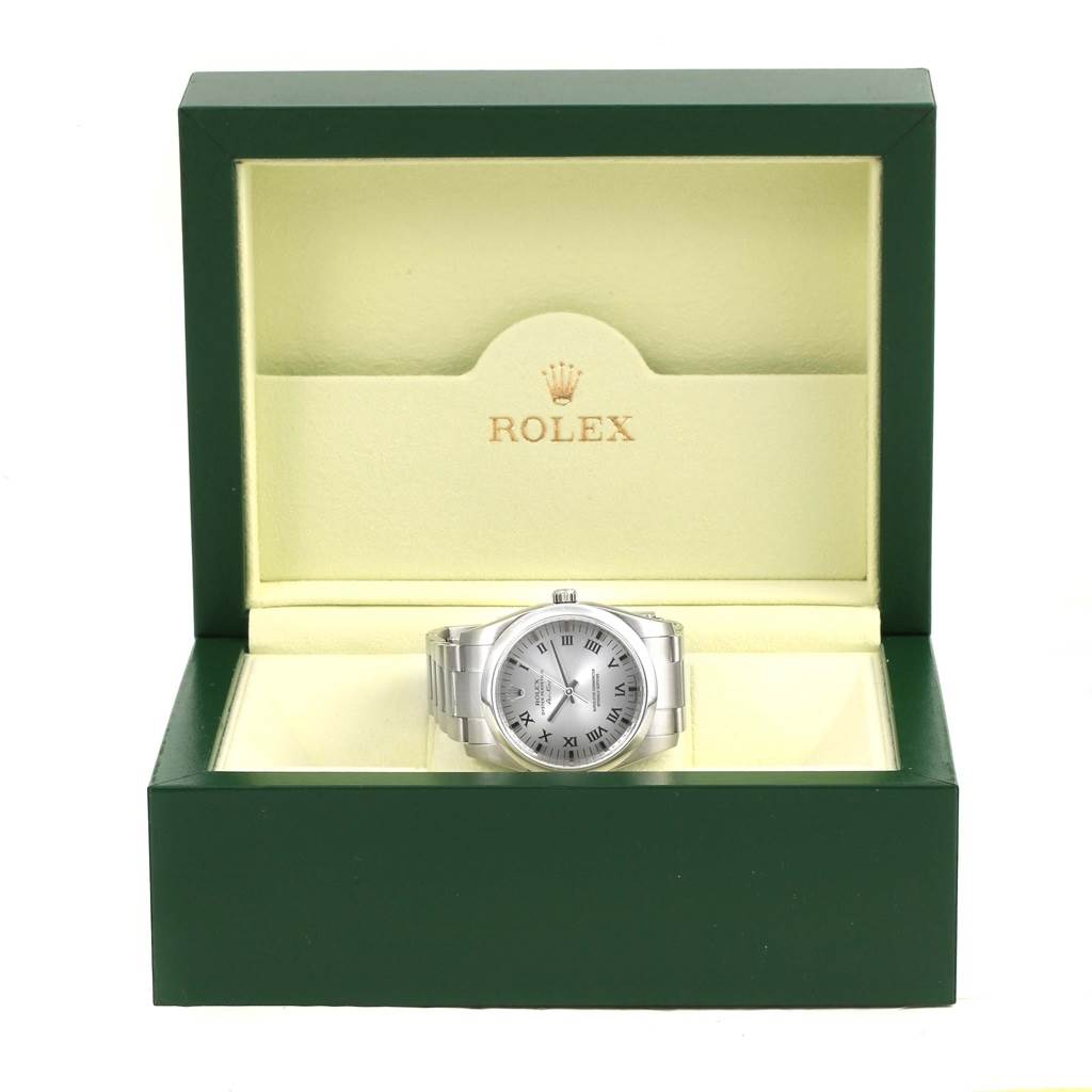 The Rolex Air-King 114200 Men's Stainless Steel Grey Dial 114200 Men's Stainless Steel Grey Dial watch is displayed frontally inside an open green and beige box, showing the face and bracelet.