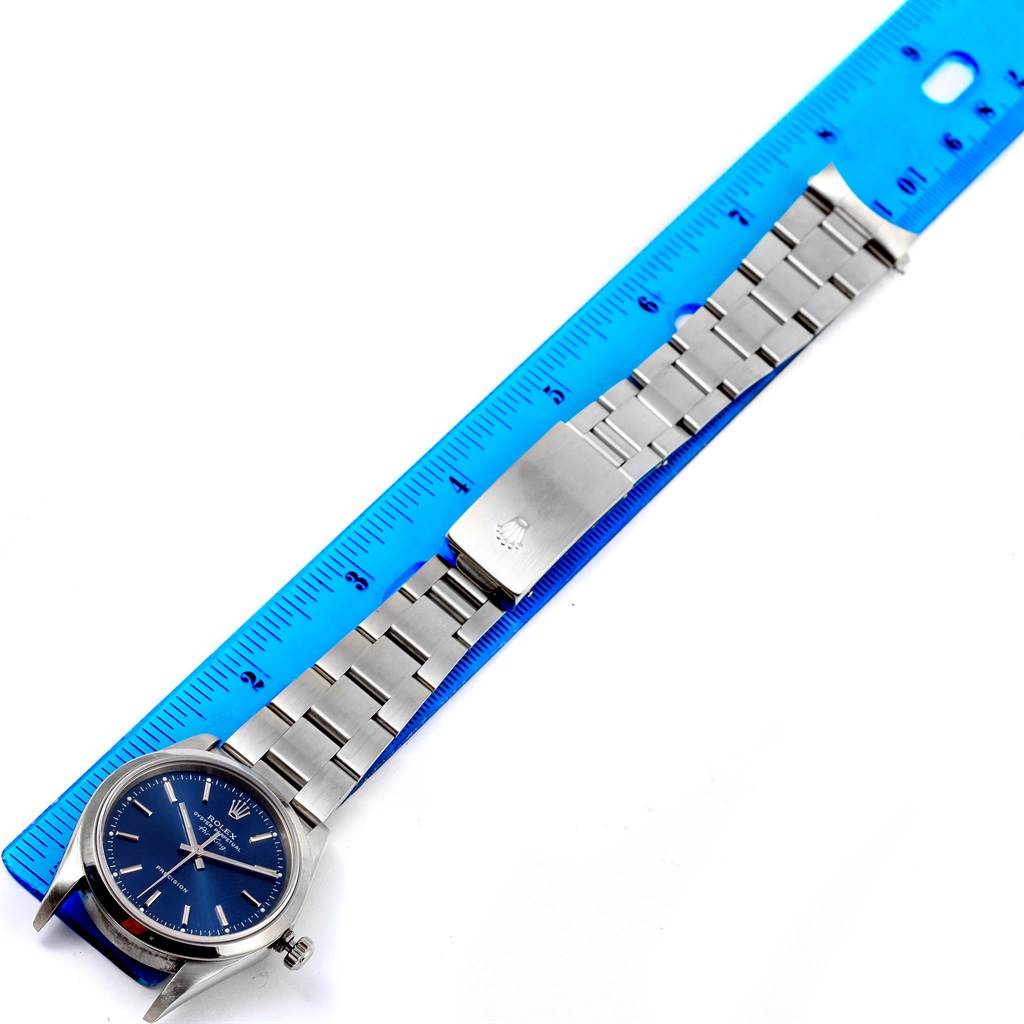 This image shows a Rolex Air-King 14000 Men's Stainless Steel Blue Dial 14000 Men's Stainless Steel Blue Dial watch laid flat with its full bracelet and clasp visible, next to a blue ruler for scale.