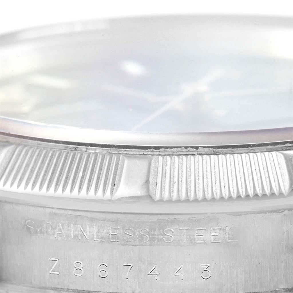 The image shows a close-up of the bezel and case back of a Rolex Air-King 114210 Men's Stainless Steel Blue Dial 114210 Men's Stainless Steel Blue Dial watch, emphasizing the stainless steel material and serial number.