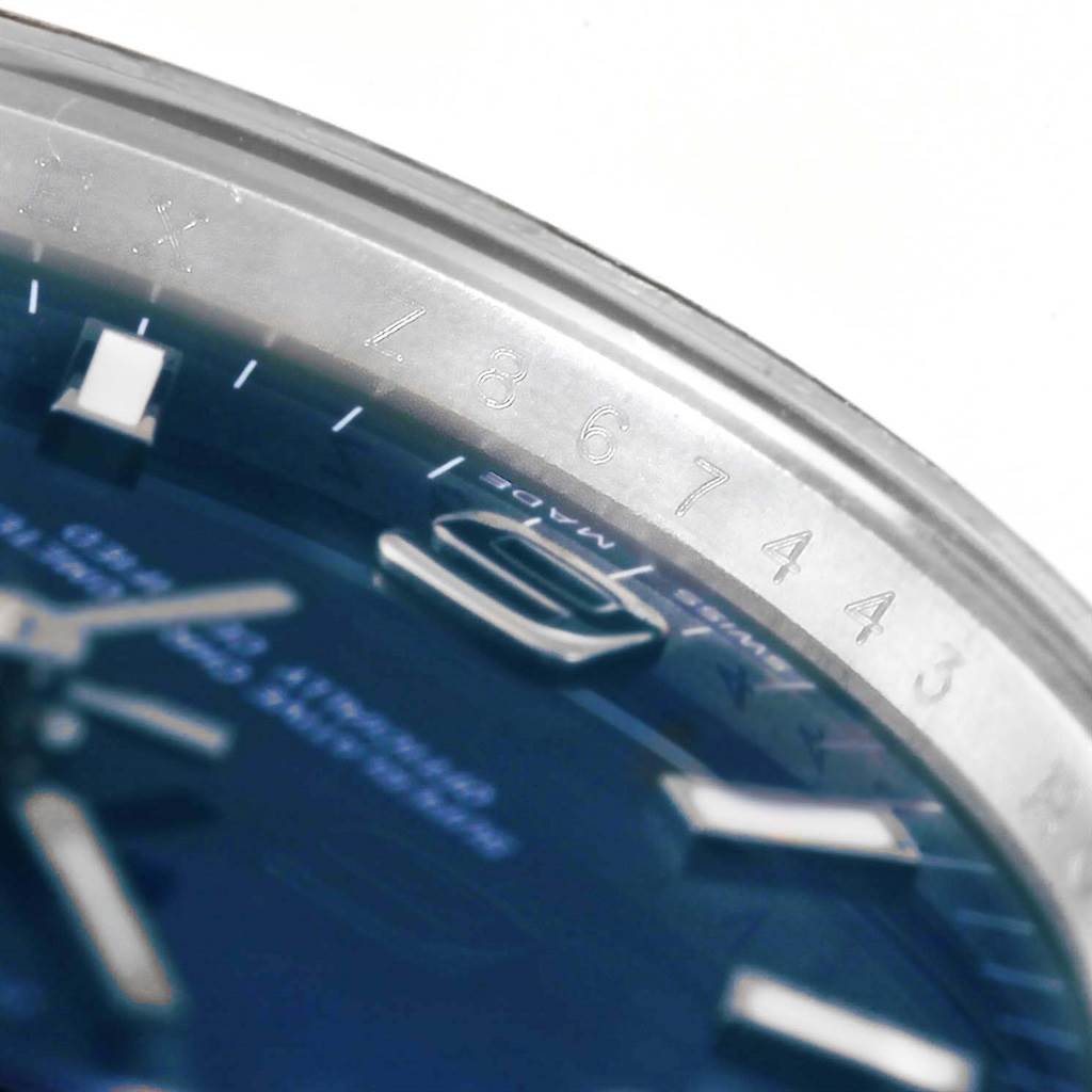 This close-up of the Rolex Air-King 114210 Men's Stainless Steel Blue Dial 114210 Men's Stainless Steel Blue Dial watch shows part of the dial and engraved bezel with the serial number.