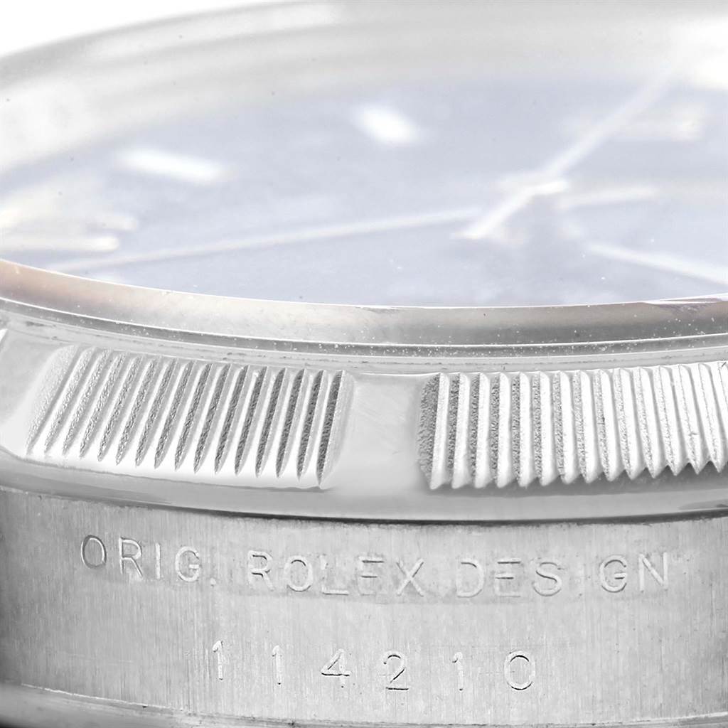 The image shows a close-up of the side and bezel of a Rolex Air-King 114210 Men's Stainless Steel Blue Dial 114210 Men's Stainless Steel Blue Dial watch, focusing on its engraved model number and design details.
