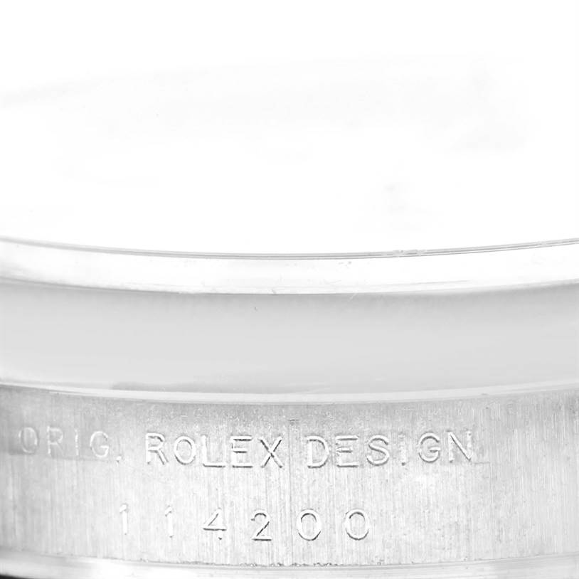 The image shows the side of a Rolex Air-King 114200 Men's Stainless Steel White Dial 114200 Men's Stainless Steel White Dial with the engraving "ORIG. ROLEX DES. GN" and the model number "114200."