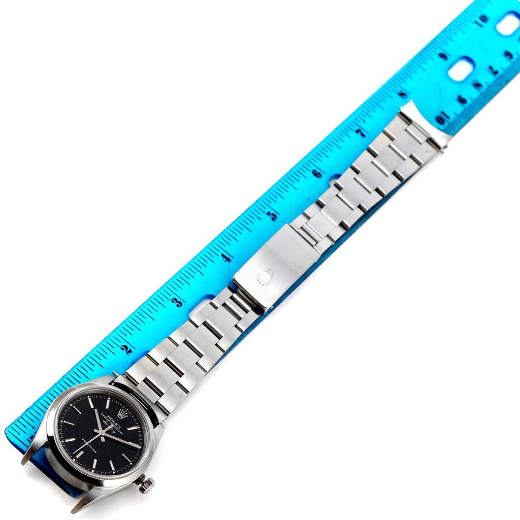 The image shows the Rolex Air-King 14000 Men's Stainless Steel Black Dial 14000 Men's Stainless Steel Black Dial watch placed alongside a ruler, displaying its bracelet and clasp.