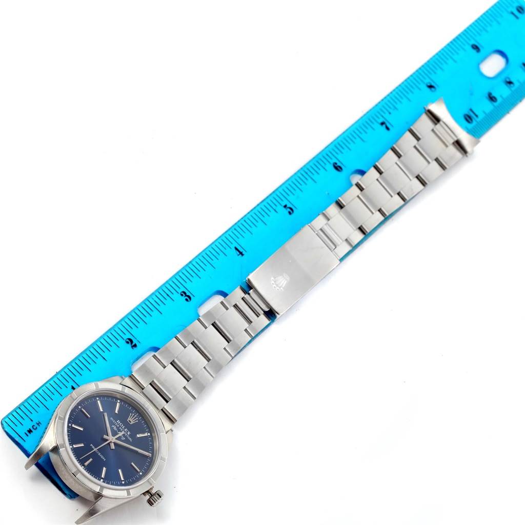 The image shows an overhead view of a Rolex Air-King 14010 Men's Stainless Steel Blue Dial 14010 Men's Stainless Steel Blue Dial watch, including its face, bracelet, and clasp, next to a ruler for size reference.