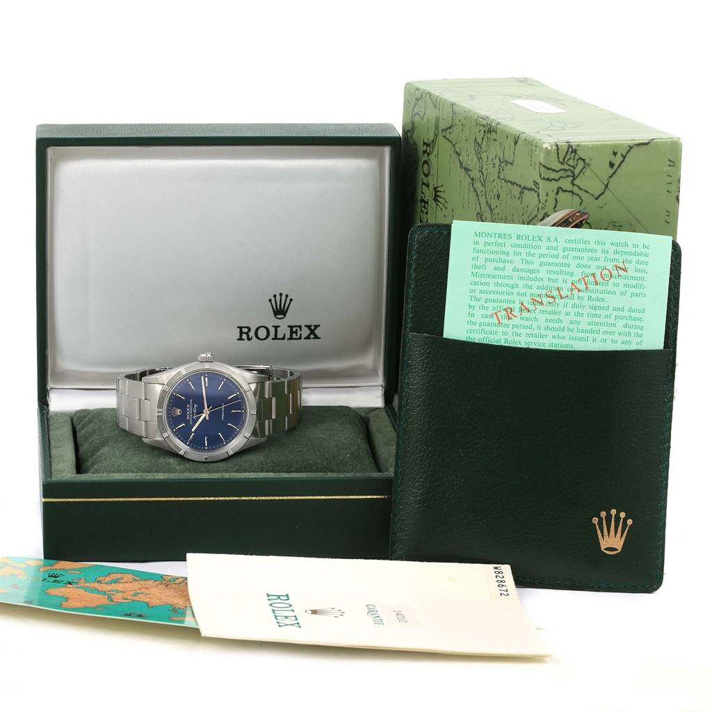 The image shows a Rolex Air-King 14010 Men's Stainless Steel Blue Dial 14010 Men's Stainless Steel Blue Dial watch in its box, along with its warranty card, booklet, and outer box.