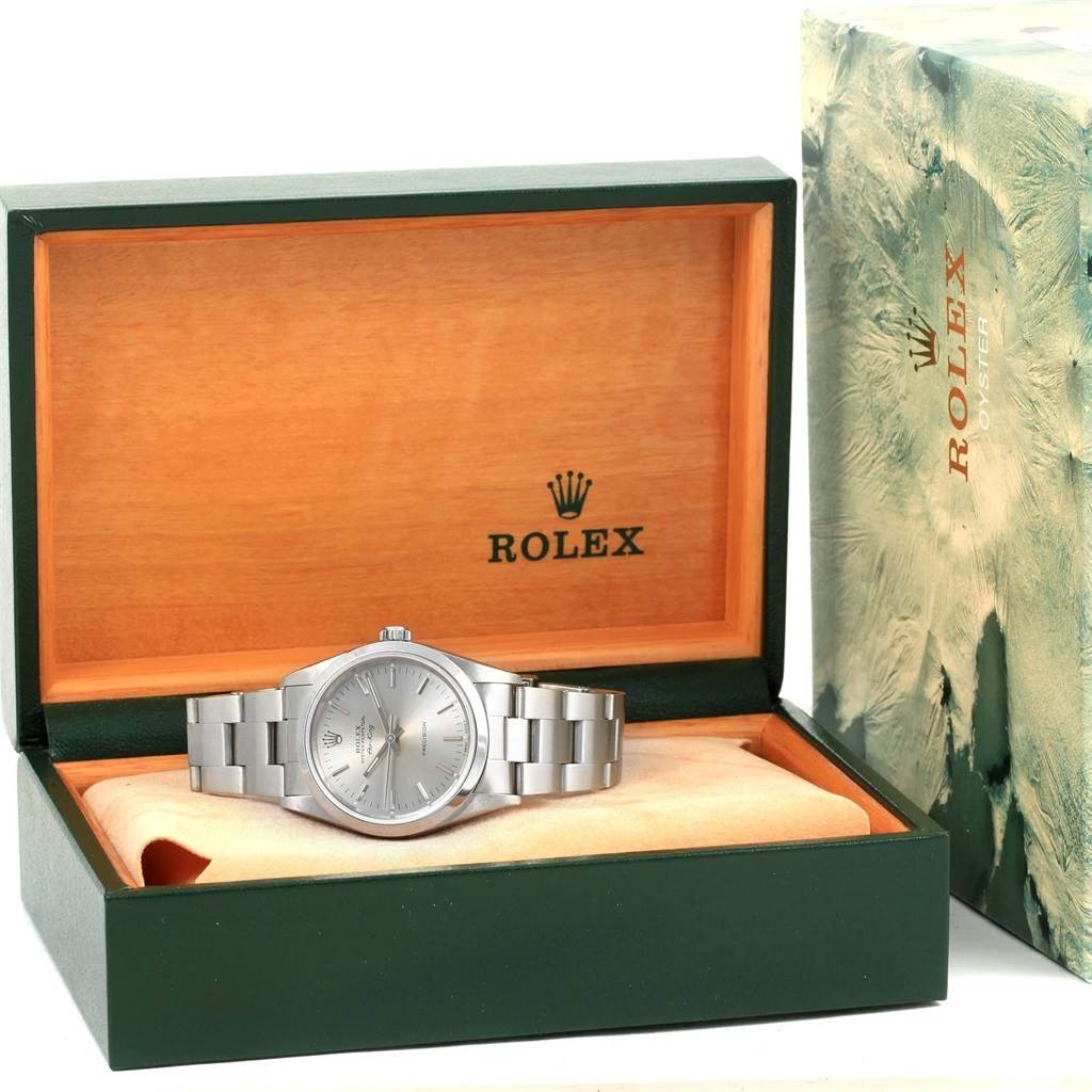 The Rolex Air-King 14000 Men's Stainless Steel Silver Dial 14000 Men's Stainless Steel Silver Dial watch is displayed inside an open green and wood-tone box, with its bracelet and face clearly visible.