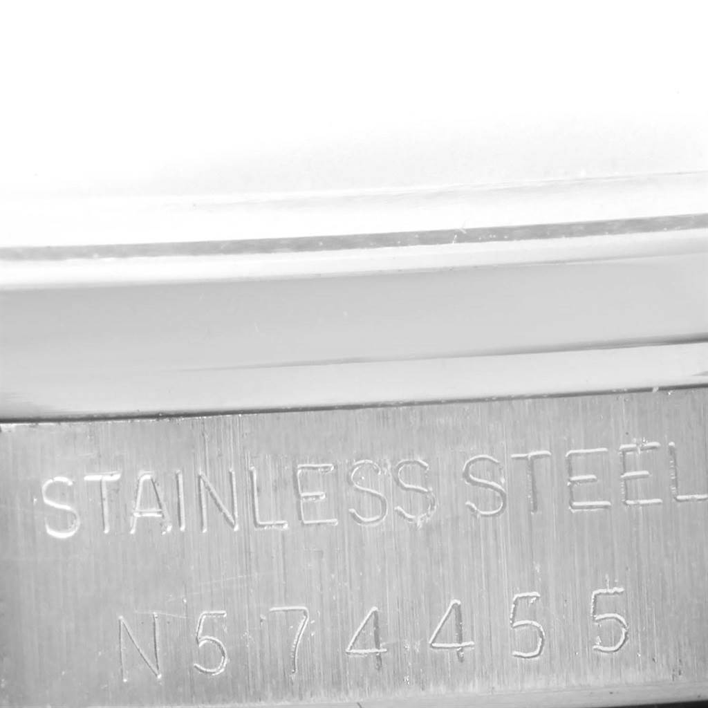 The image shows a close-up of the engraved serial number and "STAINLESS STEEL" on the casing of a Rolex Air-King 14000 Men's Stainless Steel Silver Dial 14000 Men's Stainless Steel Silver Dial watch.