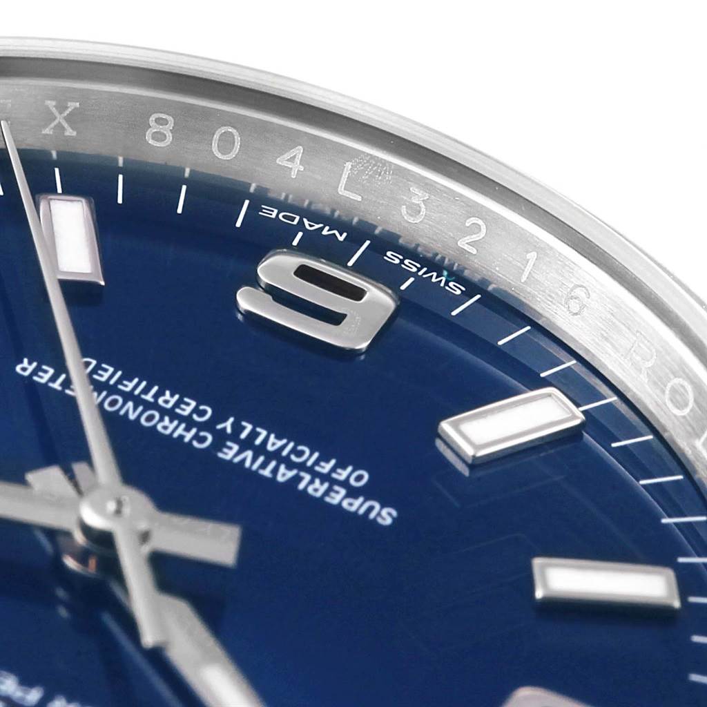 This close-up image of the Rolex Air-King 114200 Men's Stainless Steel Blue Dial 114200 Men's Stainless Steel Blue Dial watch shows part of the dial, including numbers and markers, along with the watch hands.