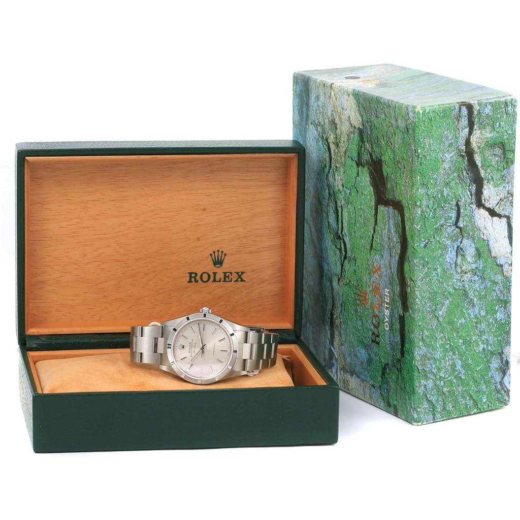 The Rolex Air-King 14010 Men's Stainless Steel Silver Dial 14010 Men's Stainless Steel Silver Dial watch is displayed in its open wooden and green case with its outer box beside it.