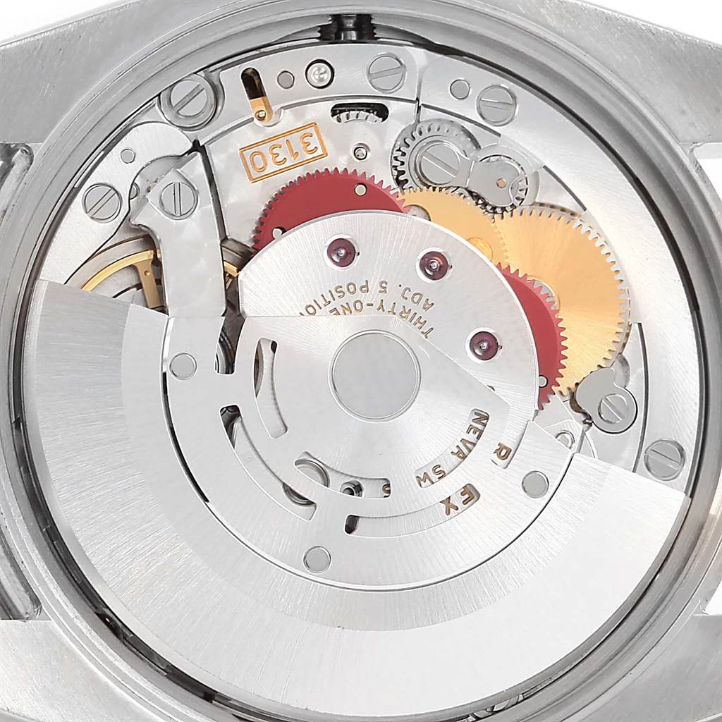 The image shows the intricate inner mechanism of a Rolex Air-King 114200 Men's Stainless Steel Blue Dial 114200 Men's Stainless Steel Blue Dial watch, showcasing its gears and movement.