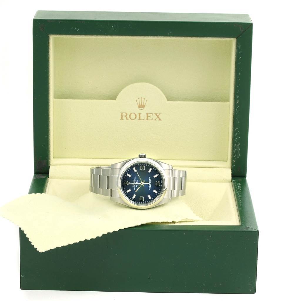 The Rolex Air-King 114200 Men's Stainless Steel Blue Dial 114200 Men's Stainless Steel Blue Dial watch is displayed in an open box, showing its face and metal band.