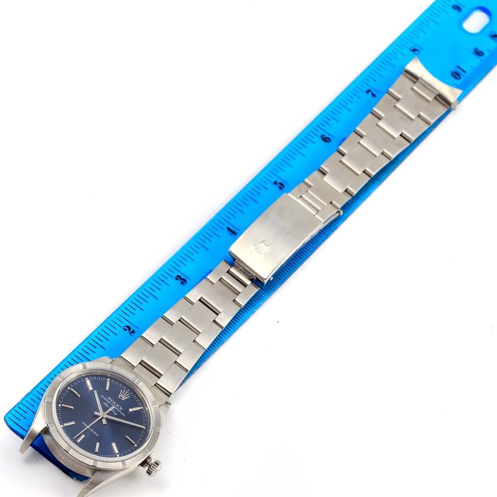The image shows a full view of the Rolex Air-King 14010 Men's Stainless Steel Blue Dial 14010 Men's Stainless Steel Blue Dial watch lying flat next to a blue ruler.