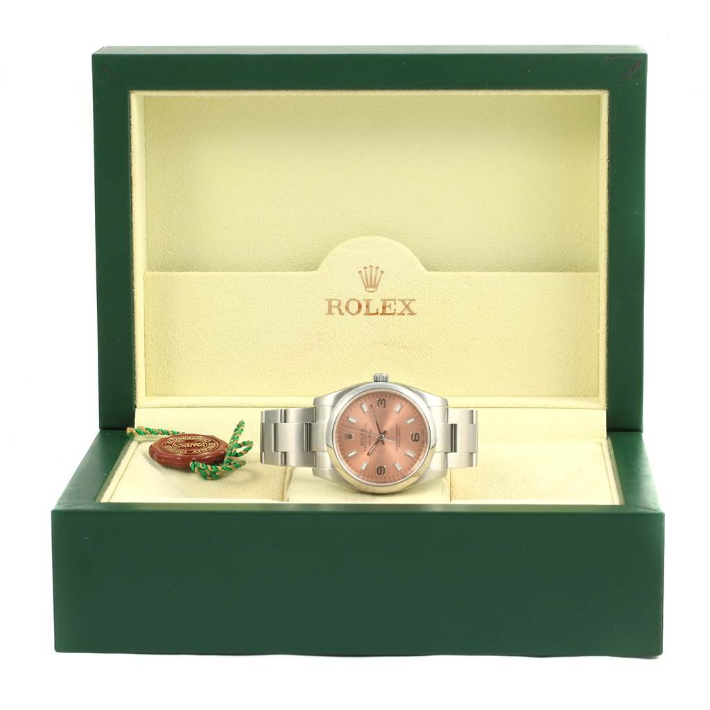 The Rolex Air-King 114200 Men's Stainless Steel Pink Dial 114200 Men's Stainless Steel Pink Dial watch is displayed front-on in its green box, with the bracelet and hang tag visible.