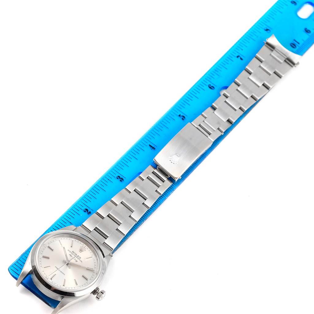 The Rolex Air-King 14000 Men's Stainless Steel Silver Dial 14000 Men's Stainless Steel Silver Dial watch in the image is positioned flat with its bracelet fully extended, alongside a blue ruler for scale.