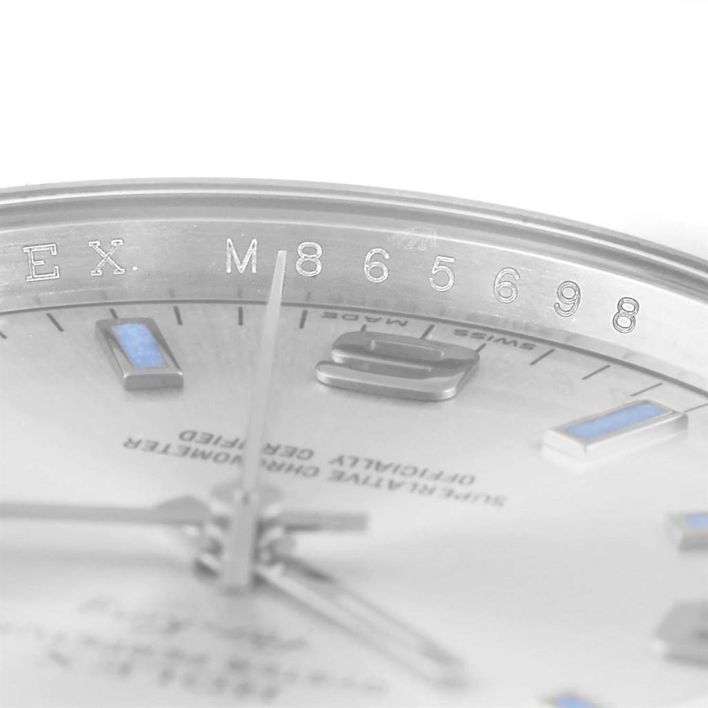 This image shows a close-up angled view of the serial number and partial dial of a Rolex Air-King 114200 Men's Stainless Steel Silver Dial 114200 Men's Stainless Steel Silver Dial watch.
