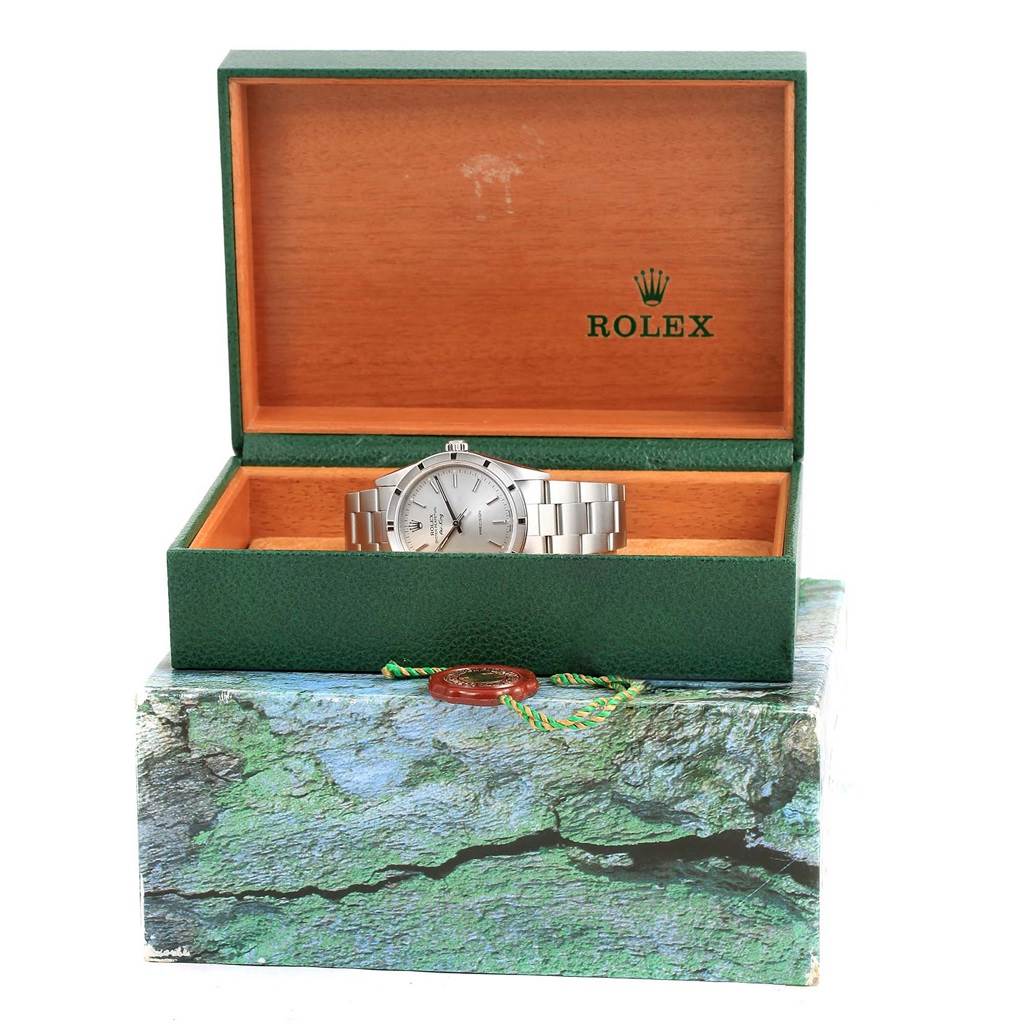 The Rolex Air-King 14010 Men's Stainless Steel Silver Dial 14010 Men's Stainless Steel Silver Dial watch is shown inside an open green and wooden branded box, viewed from the front.