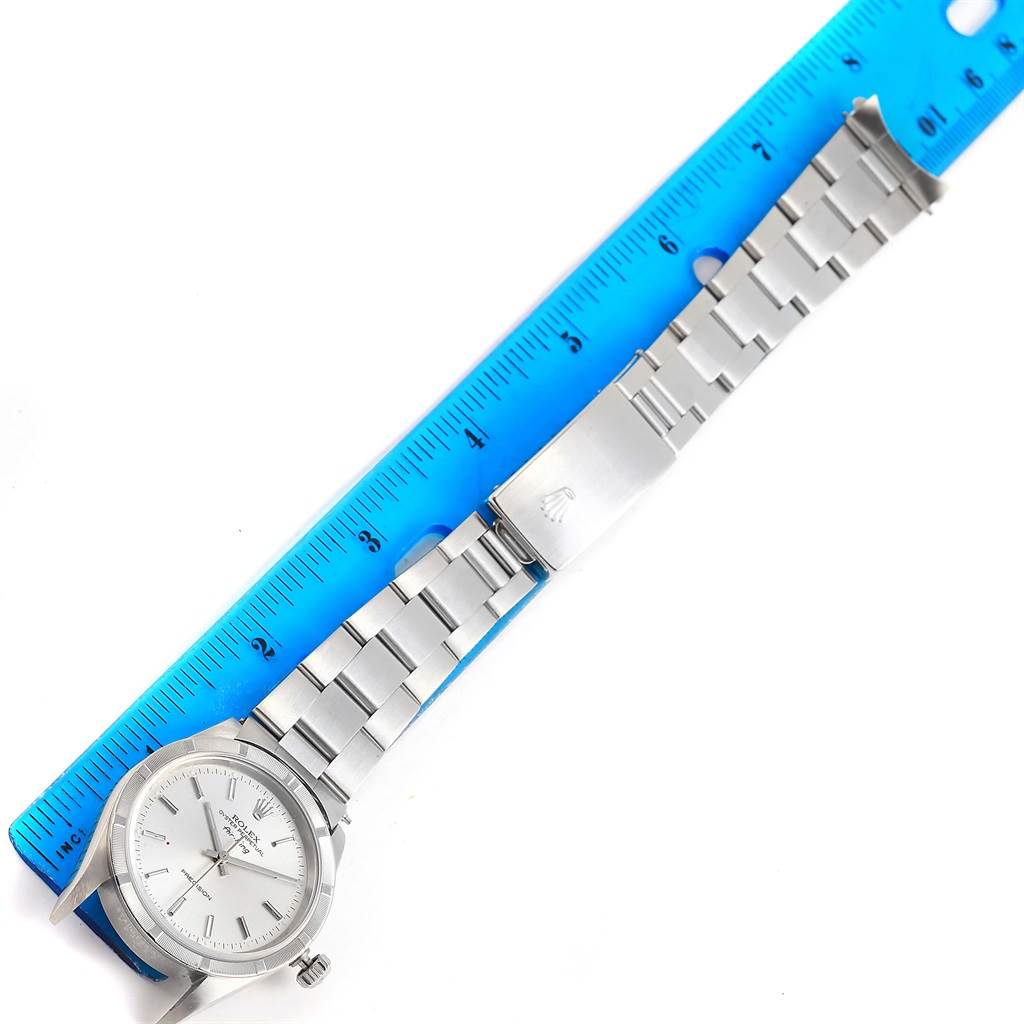 The image shows a Rolex Air-King 14010 Men's Stainless Steel Silver Dial 14010 Men's Stainless Steel Silver Dial watch from a top-down angle featuring its face, bracelet, and clasp alongside a ruler.