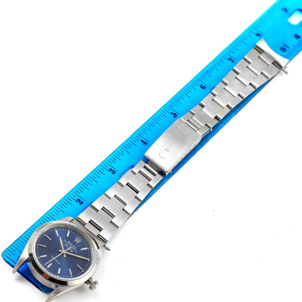 The image shows a Rolex Air-King 14000 Men's Stainless Steel Blue Dial 14000 Men's Stainless Steel Blue Dial watch, laid flat with a blue ruler measuring its metal bracelet.