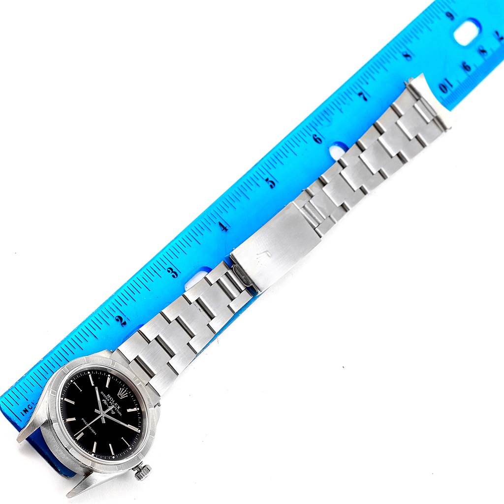 The image shows a Rolex Air-King 14010 Men's Stainless Steel Black Dial 14010 Men's Stainless Steel Black Dial watch with a stainless steel bracelet placed alongside a blue ruler for measurement.