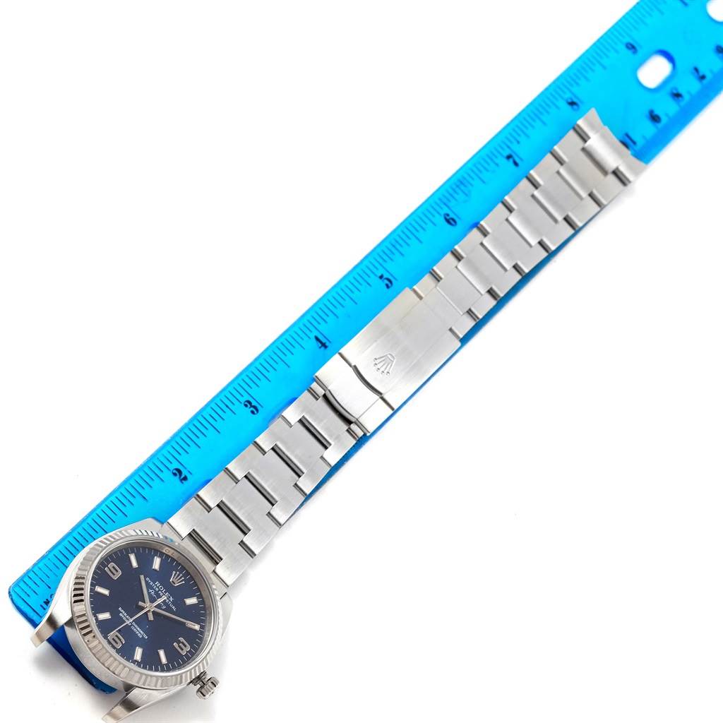 The image shows the face and strap of a Rolex Air-King 114234 Men's Stainless Steel Blue Dial 114234 Men's Stainless Steel Blue Dial watch placed alongside a blue ruler.