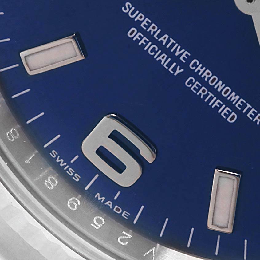 This close-up photo of the Rolex Air-King 114234 Men's Stainless Steel Blue Dial 114234 Men's Stainless Steel Blue Dial watch shows part of the blue dial, the "6" numeral, and "Swiss Made" text.