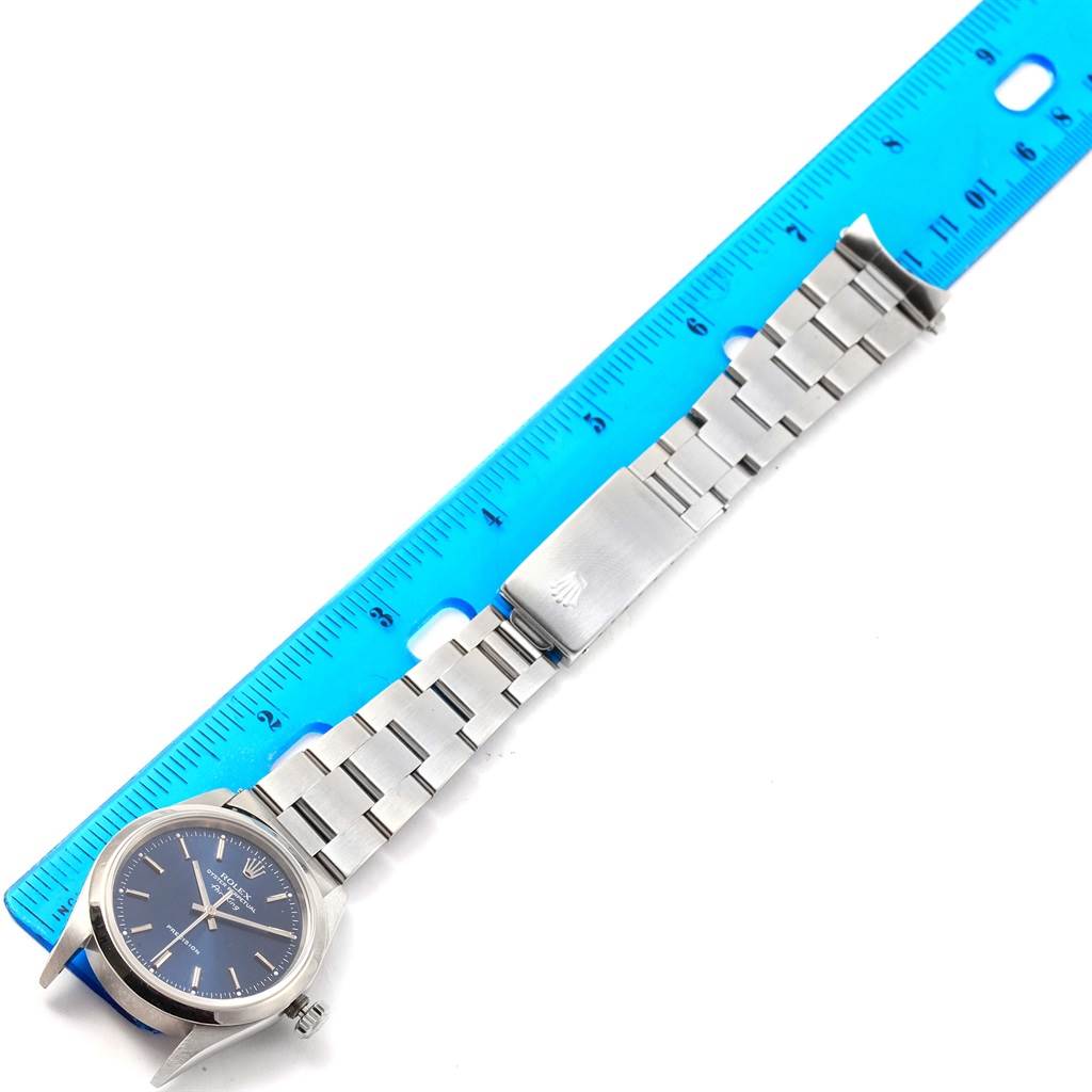 The Rolex Air-King 14000 Men's Stainless Steel Blue Dial 14000 Men's Stainless Steel Blue Dial watch is displayed flat with its face, bracelet, and clasp visible alongside a ruler for scale.