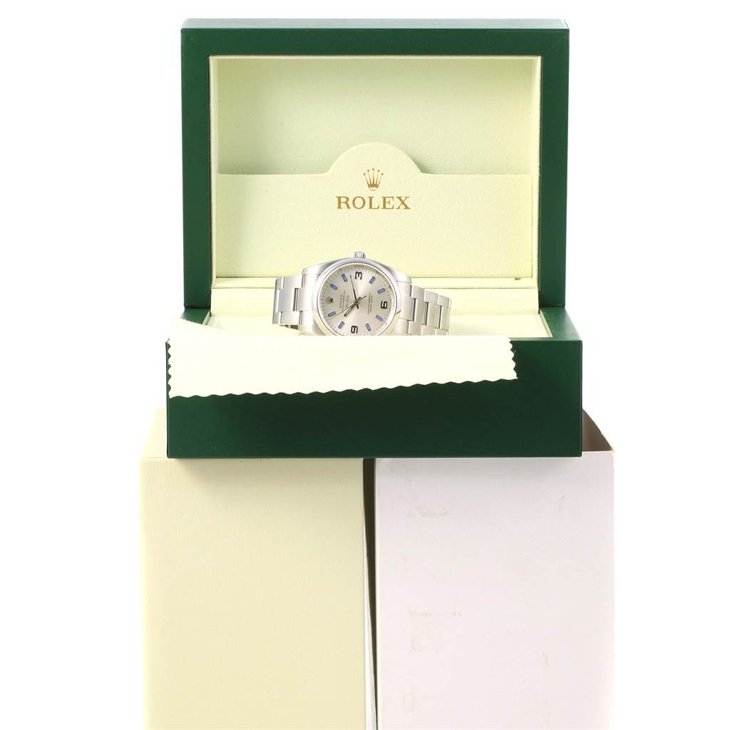 A Rolex Air-King 114200 Stainless Steel Silver Dial 114200 Stainless Steel Silver Dial watch is displayed in an open green and cream Rolex box with a visible bracelet and dial.