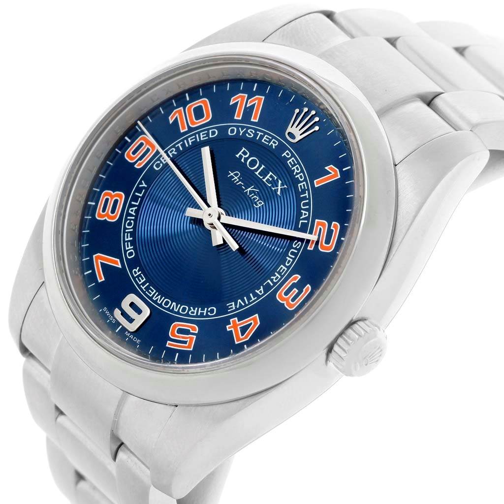 The Rolex Air-King 114200 Stainless Steel Blue Dial 114200 Stainless Steel Blue Dial watch is shown at an angled close-up, highlighting the blue dial, colorful numerals, and part of the stainless steel bracelet.