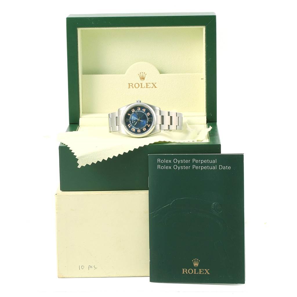The image shows a Rolex Air-King 114200 Stainless Steel Blue Dial 114200 Stainless Steel Blue Dial watch inside its green box with accompanying documentation in front.
