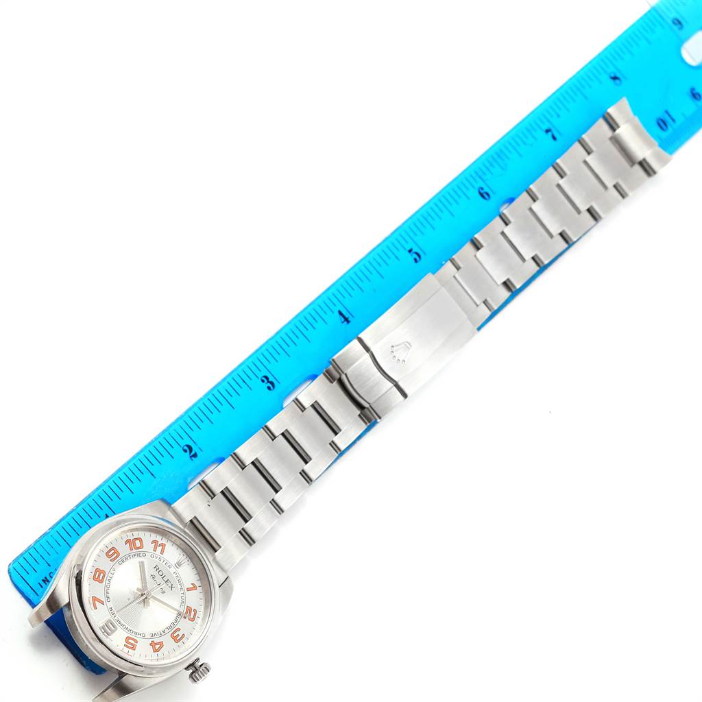 The image shows a Rolex Air-King 114200 Men's Stainless Steel Silver Dial 114200 Men's Stainless Steel Silver Dial watch laid flat next to a blue ruler, displaying the watch face, band, and clasp.