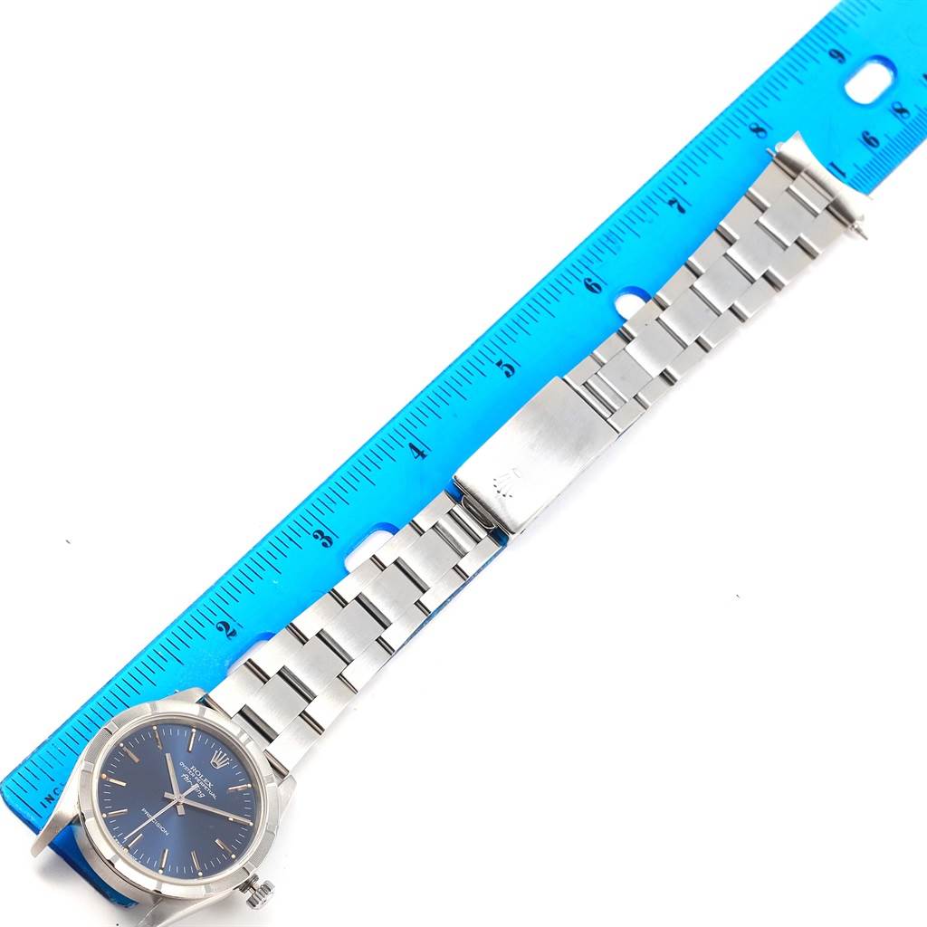 The image shows the Rolex Air-King 14010 Men's Stainless Steel Blue Dial 14010 Men's Stainless Steel Blue Dial watch laid flat with a blue ruler alongside, highlighting the metal bracelet and clasp.