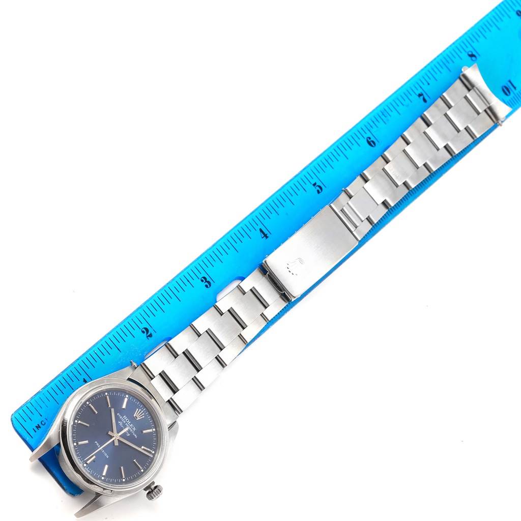 The Rolex Air-King 14000 Stainless Steel Blue Dial 14000 Stainless Steel Blue Dial watch is shown from a top-down angle with the full metal bracelet and part of a blue ruler for measurement.