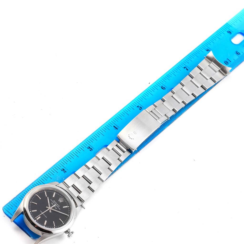 The image shows an overhead view of a Rolex Air-King 14000 Stainless Steel Black Dial 14000 Stainless Steel Black Dial watch, highlighting its face, strap, and clasp aligned alongside a ruler for measurement.