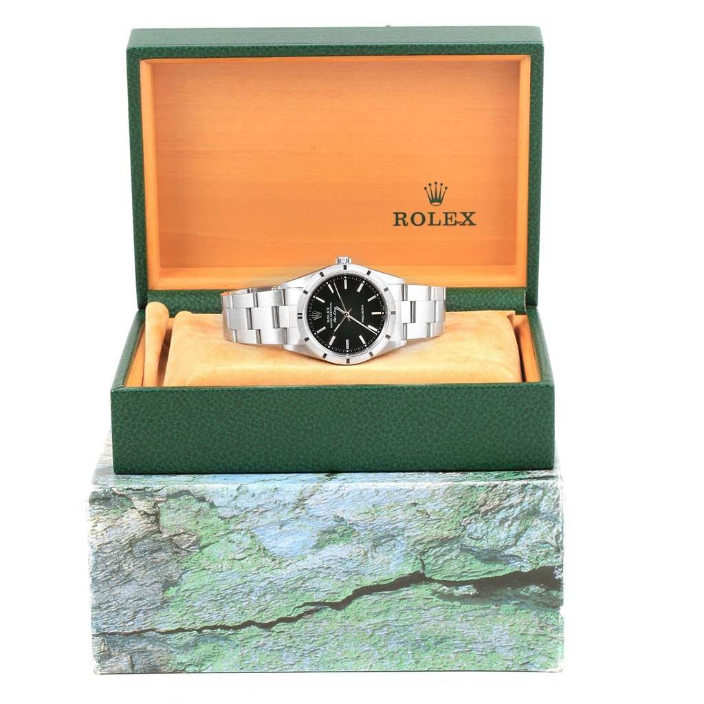 The Rolex Air-King 14010 Men's Stainless Steel Black Dial 14010 Men's Stainless Steel Black Dial watch is shown front-facing in an open green and orange Rolex box with a metal bracelet.