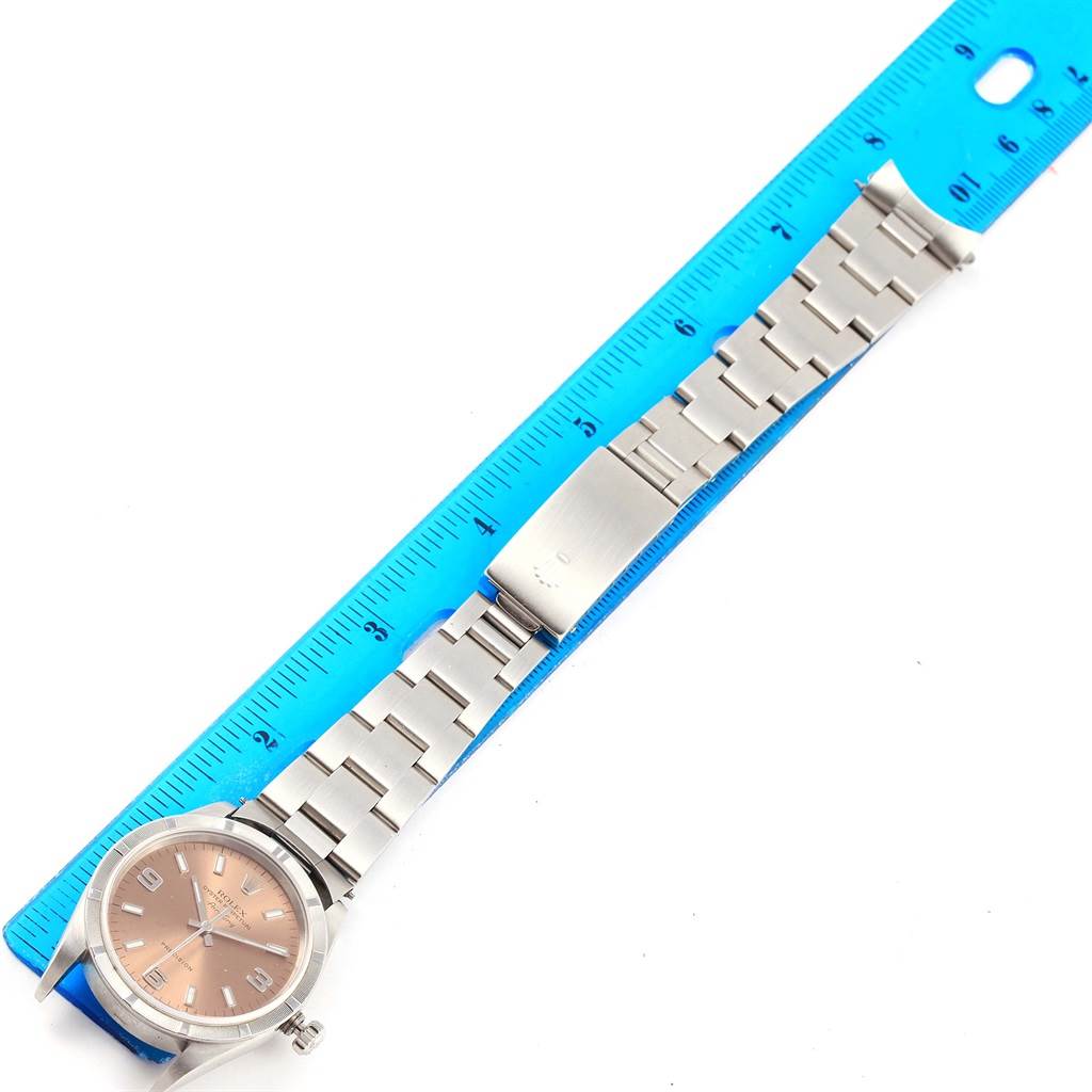 The image shows a Rolex Air-King 14010 Stainless Steel Pink Dial 14010 Stainless Steel Pink Dial watch laid flat next to a blue ruler, displaying its entire face and metal bracelet.