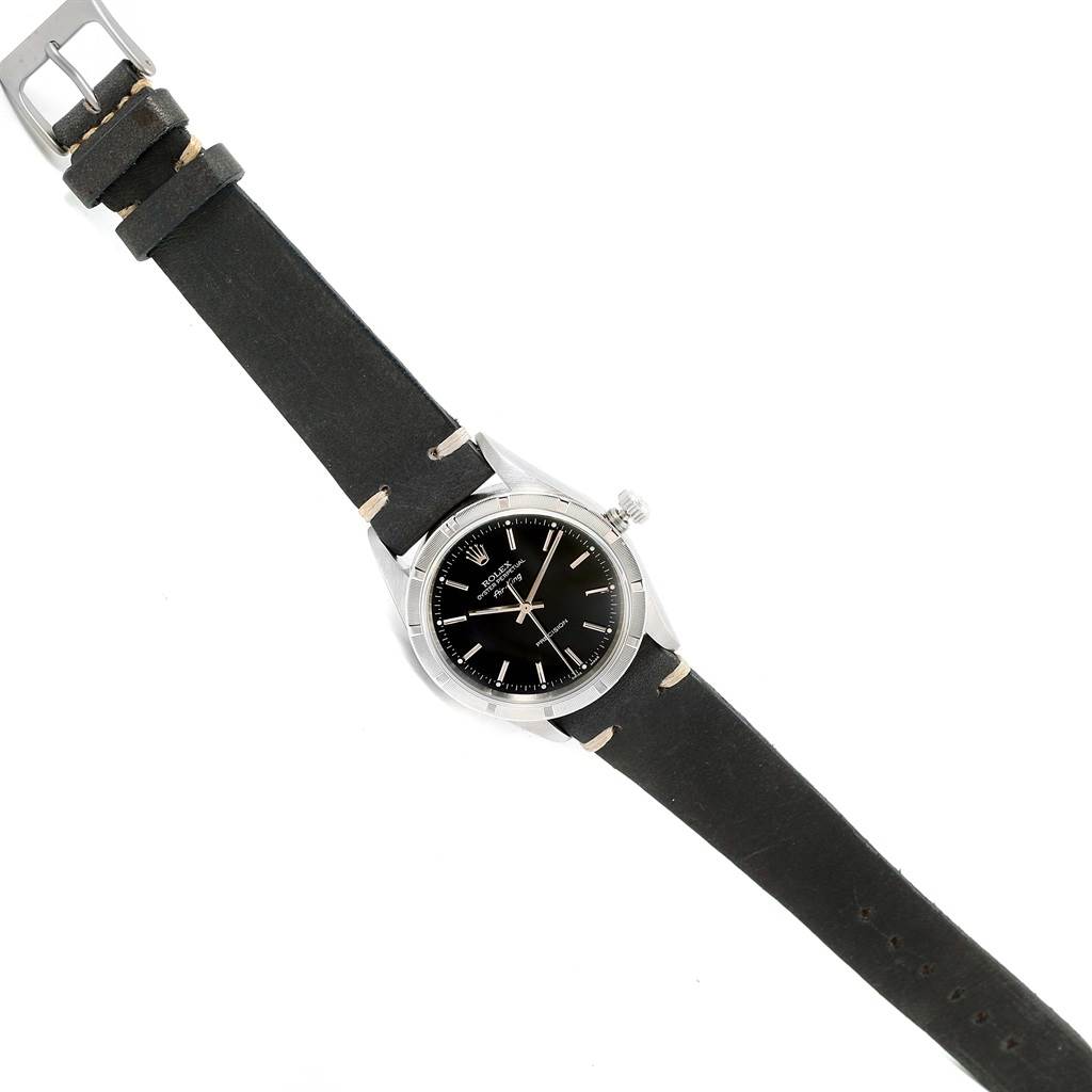 The image shows a top-down view of a Rolex Air-King 14010 Men's Stainless Steel Black Dial 14010 Men's Stainless Steel Black Dial watch with a black dial and a black leather strap.