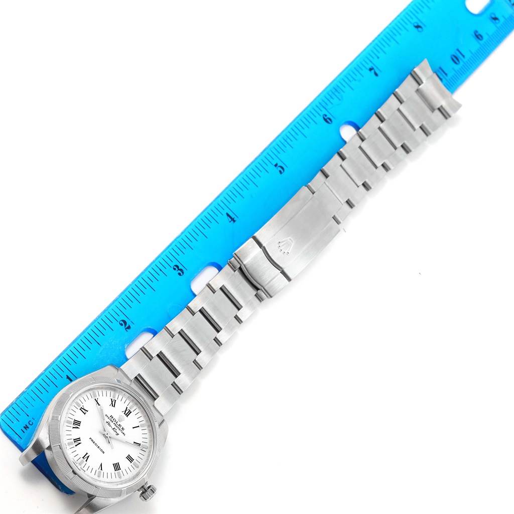 The image shows a Rolex Air-King 114210 Men's Stainless Steel White Dial 114210 Men's Stainless Steel White Dial watch laid flat next to a blue ruler, displaying the watch face and metal bracelet.