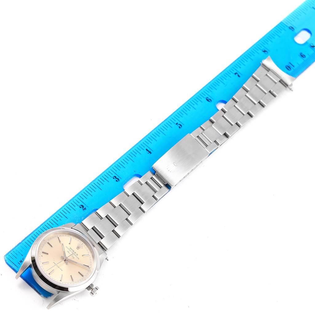 The Rolex Air-King 14000 Men's Stainless Steel Silver Dial 14000 Men's Stainless Steel Silver Dial watch is shown from a top-down angle, displaying its face, bracelet, and clasp alongside a blue ruler for scale.