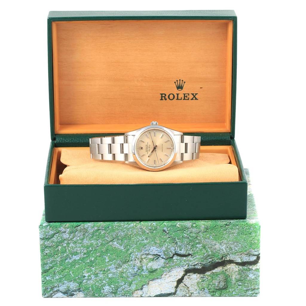 The Rolex Air-King 14000 Men's Stainless Steel Silver Dial 14000 Men's Stainless Steel Silver Dial watch is shown front-facing inside an open green box with an orange cushion.