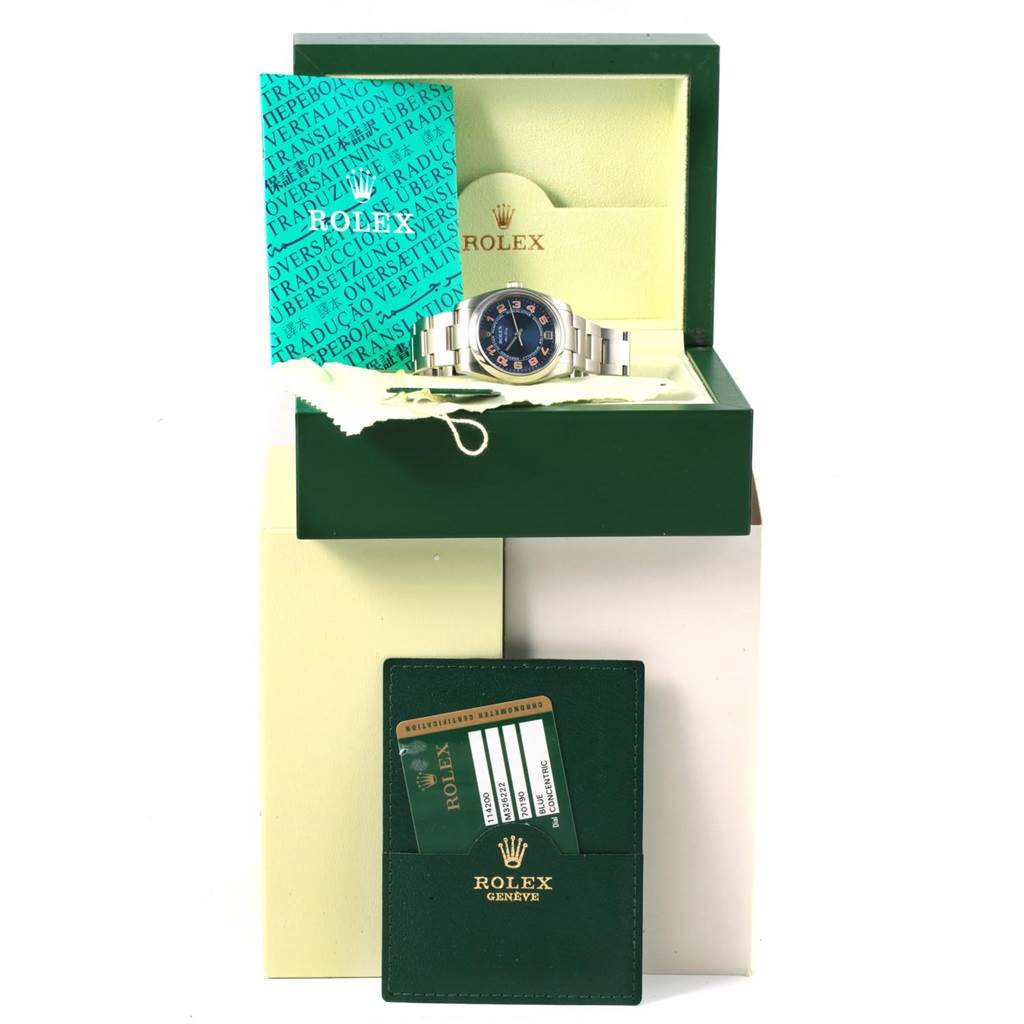 The image shows a Rolex Air-King 114200 Men's Stainless Steel Blue Dial 114200 Men's Stainless Steel Blue Dial watch in its box, along with documentation and a green cardholder.