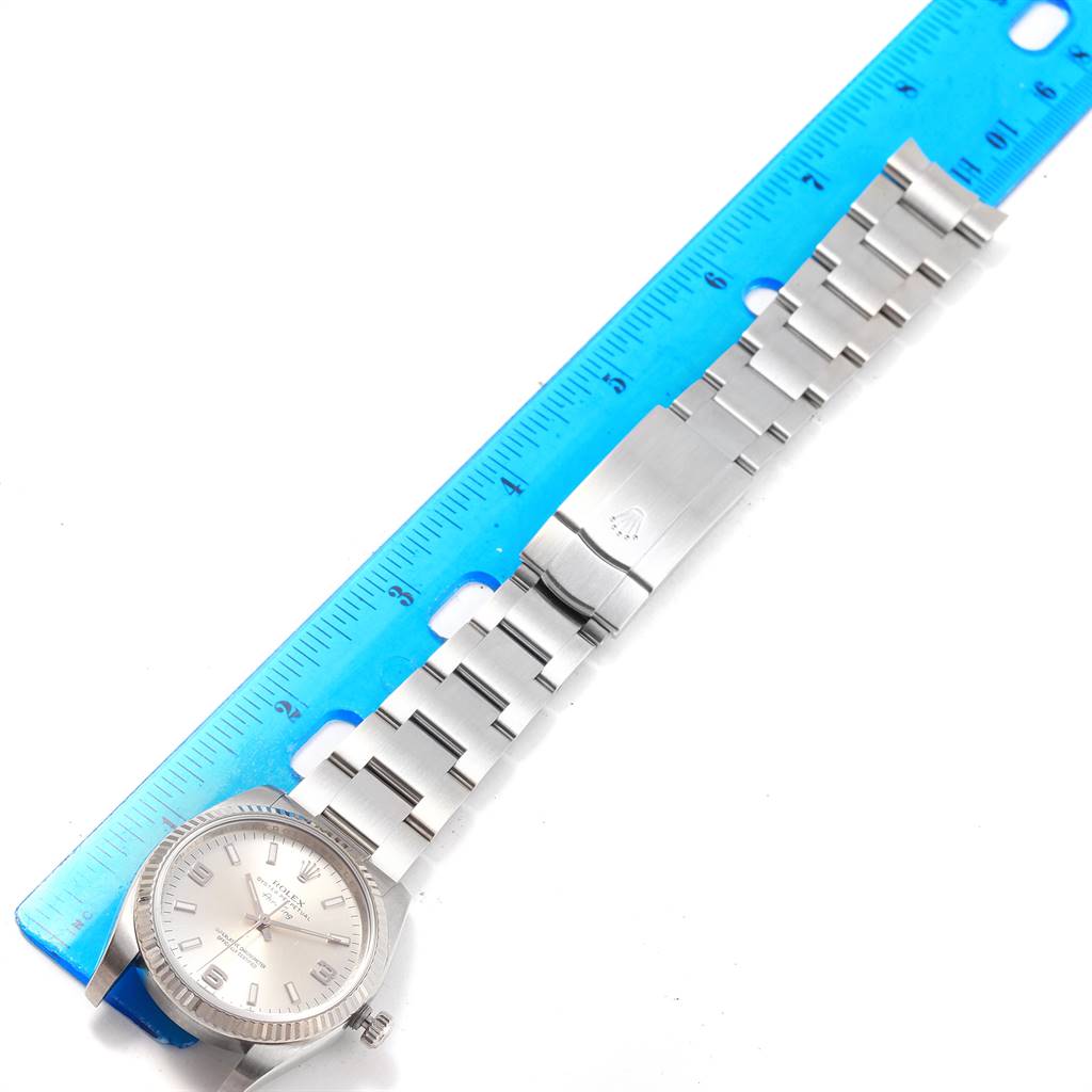 The image shows the face and bracelet of a Rolex Air-King 114234 Men's Stainless Steel Silver Dial 114234 Men's Stainless Steel Silver Dial watch, positioned next to a blue ruler for scale.