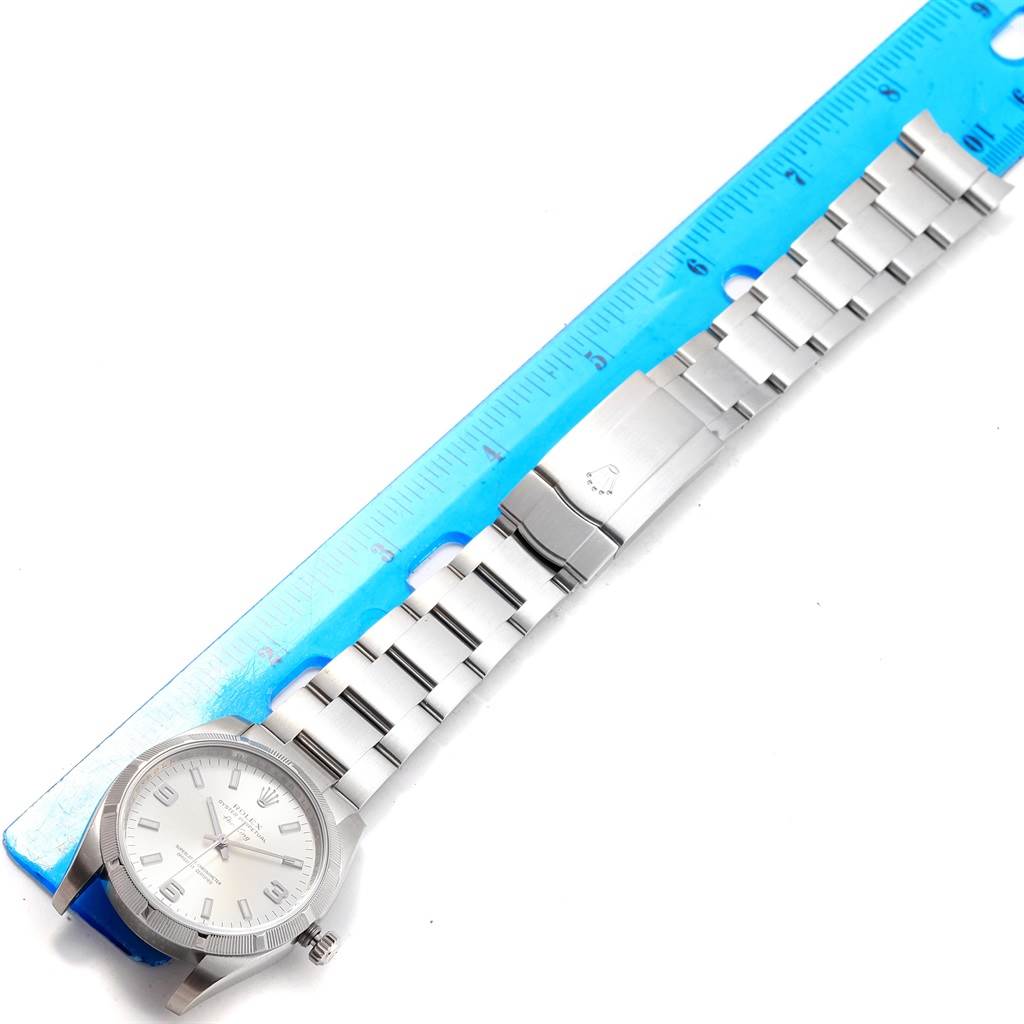 The image shows a Rolex Air-King 114210 Men's Stainless Steel Silver Dial 114210 Men's Stainless Steel Silver Dial watch, laid flat with the face and stainless steel bracelet visible and measured against a ruler.