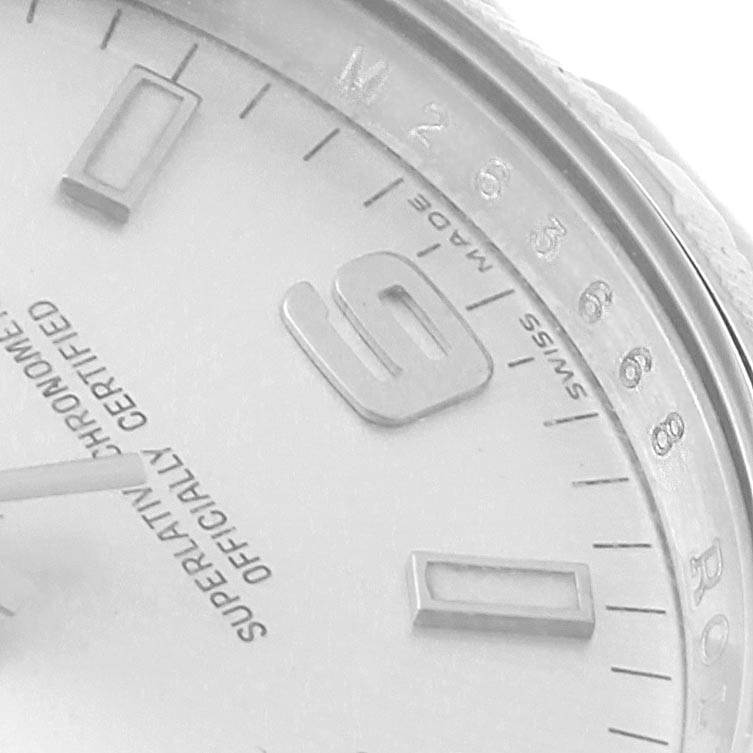 This close-up image of the Rolex Air-King 114210 Men's Stainless Steel Silver Dial 114210 Men's Stainless Steel Silver Dial watch shows part of the dial, index markers, numerals, and a portion of the bezel.