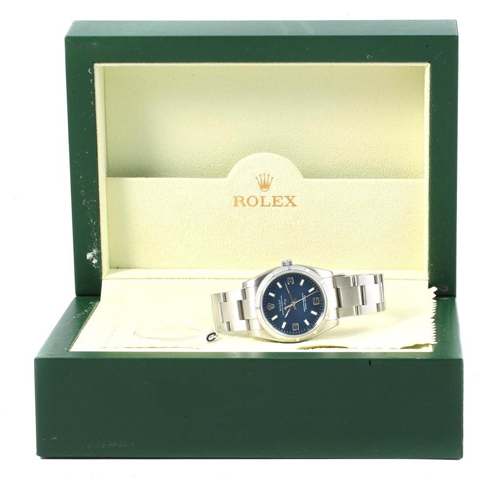 The image shows a front-facing Rolex Air-King 114210 Men's Stainless Steel Blue Dial 114210 Men's Stainless Steel Blue Dial watch inside its green and cream-colored box.