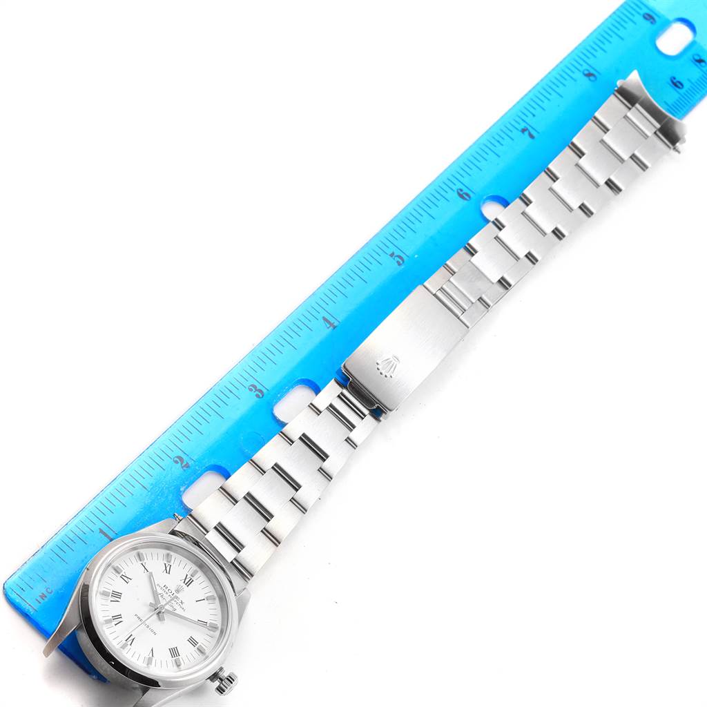 The Rolex Air-King 14000 Men's Stainless Steel White Dial 14000 Men's Stainless Steel White Dial watch is shown from a top-down angle, displaying its face, bracelet, and clasp alongside a blue ruler.