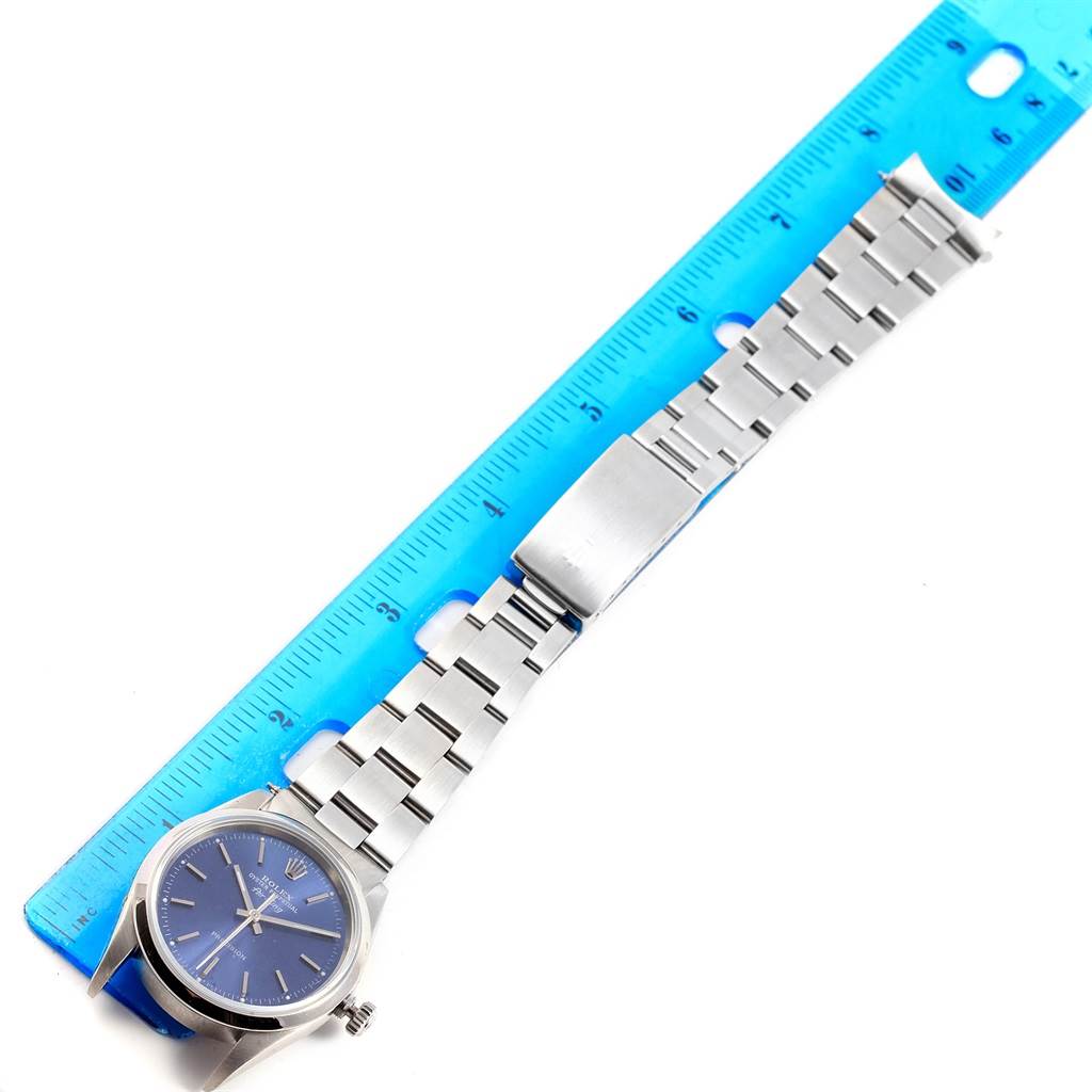 The image shows a Rolex Air-King 14000 Men's Stainless Steel Blue Dial 14000 Men's Stainless Steel Blue Dial watch laid flat, next to a blue ruler, highlighting the watch face, bracelet, and clasp.